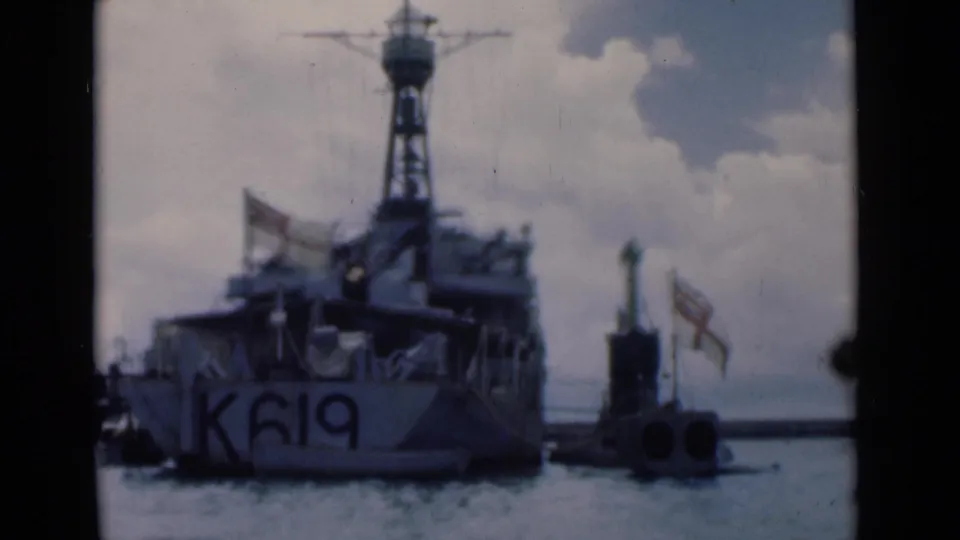 The K619-marked vessel remains moored in Colombo harbor, with a small marker to the right and cloud cover above the ship.