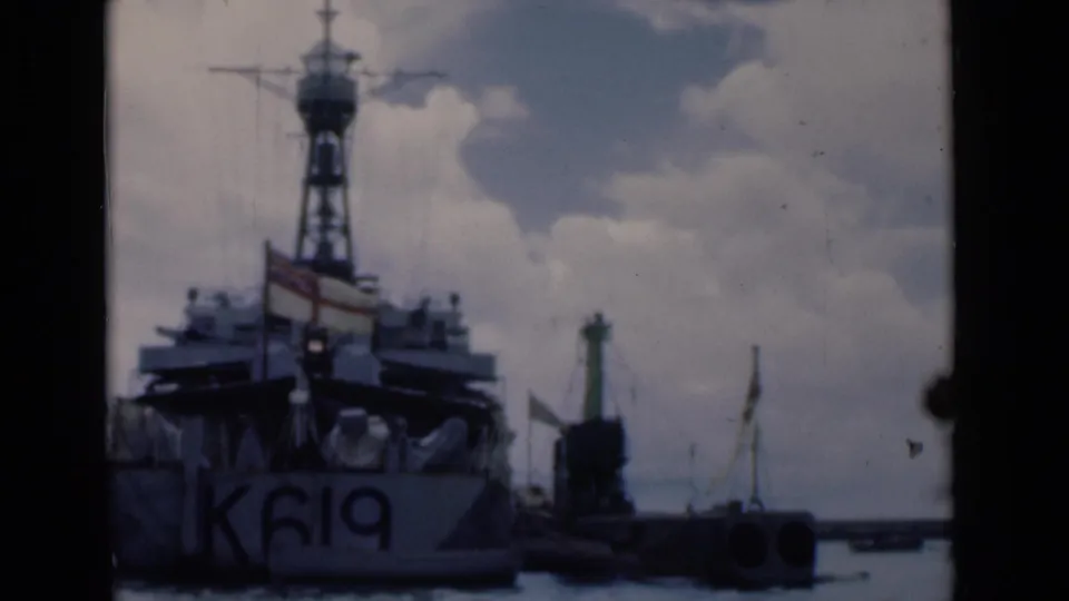 1946 Colombo harbor view showing a naval vessel marked K619 near the quay, seen through dark film-frame edges.