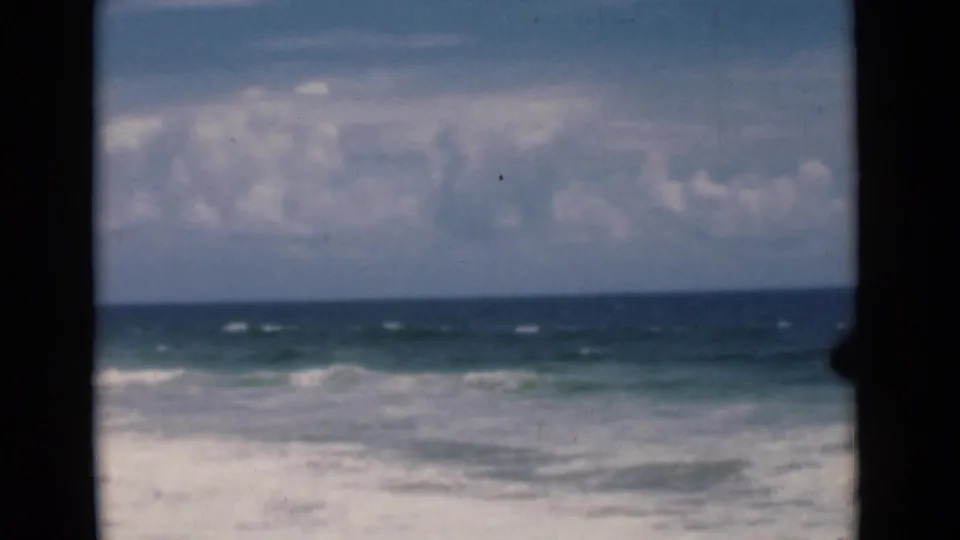 A 1946 8mm view shifts from harbor observation to open ocean, with low waves under a cloudy sky.