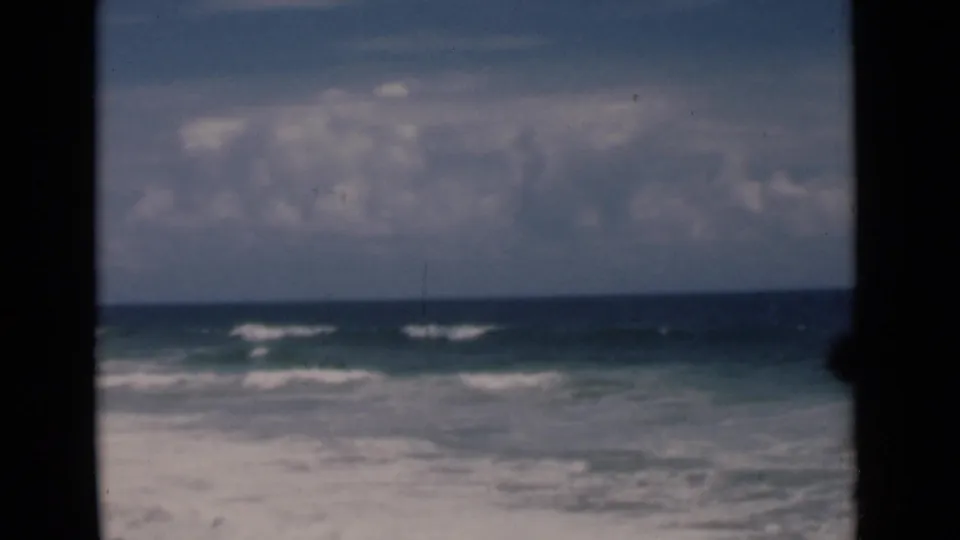 Open sea and gentle surf are seen through a dark boat-window frame in Colombo-area 1946 travel footage.