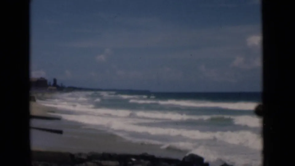 1946 Colombo coastal view showing a pale beach, active surf, rocks in the foreground, and a low distant shoreline.