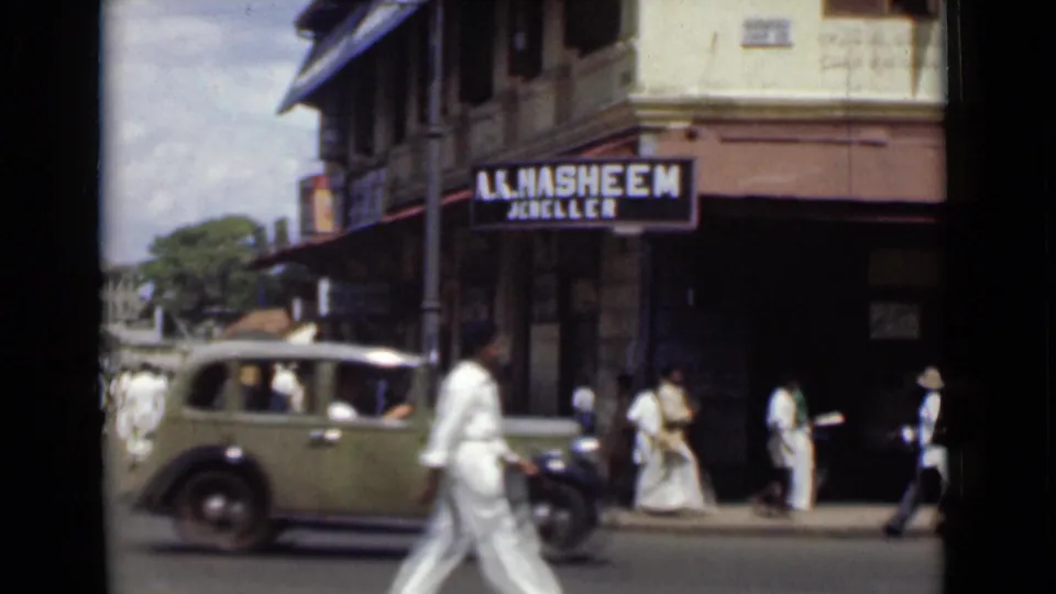 A 1946 Colombo shop corner shows a jeweller sign above pedestrians, an umbrella, and a vintage car passing through the street.
