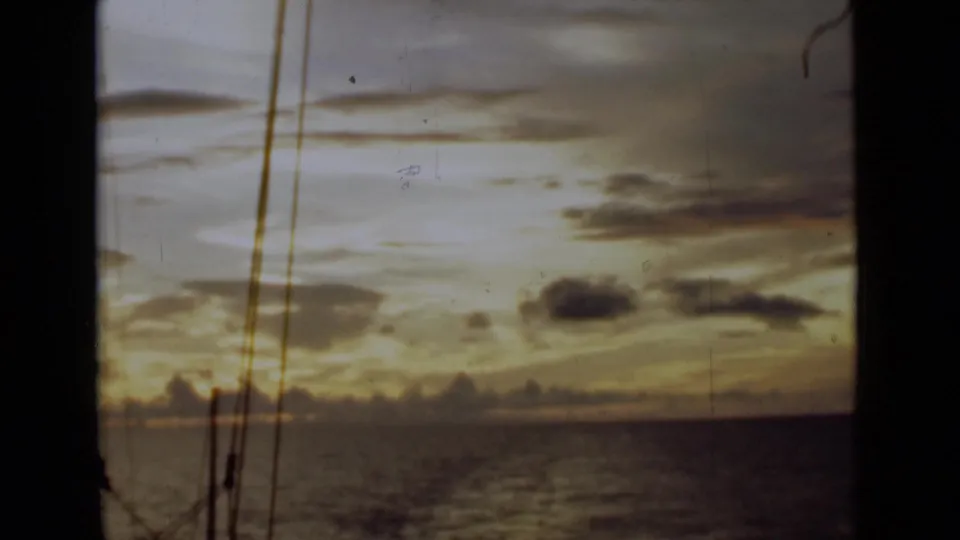 1946 shipboard view near Colombo, Ceylon, showing golden clouds over the sea with dark rigging in the foreground.