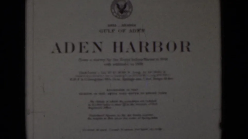 A home-movie title card reading Aden Harbor, with smaller printed lines and an emblem above the title.