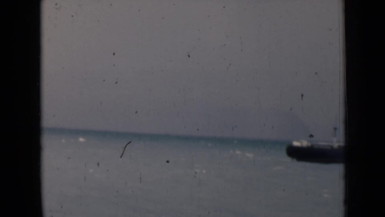 Distant ship near the right edge beyond a dark window frame.