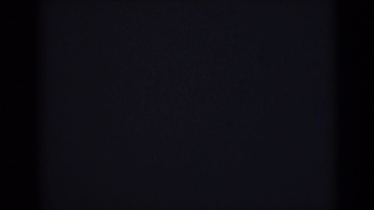 Nearly black frame from the 1946 India 8mm clip, showing faint gate edges, grain, and very low exposure.