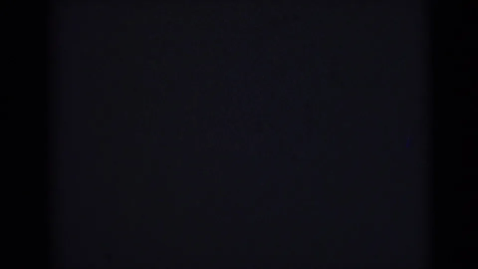 Nearly black frame from the 1946 India 8mm clip, showing faint gate edges, grain, and very low exposure.