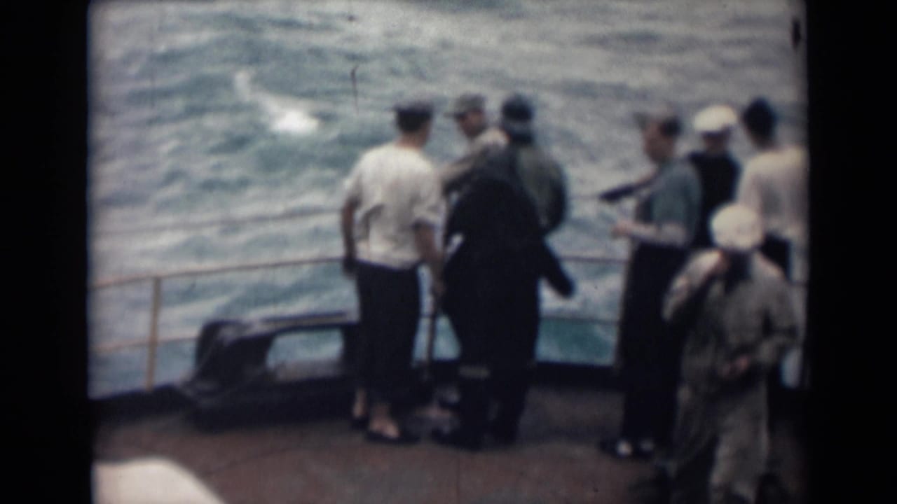 In this 1946 India shipboard frame, several crew members in caps stand near the rail while rough water moves alongside the deck.