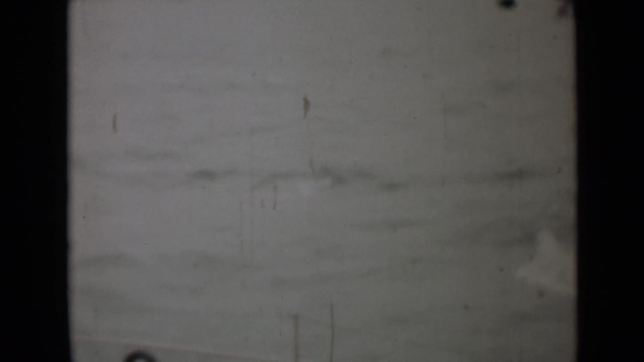 Blurred view of rough ocean with a faint figure near the right edge.