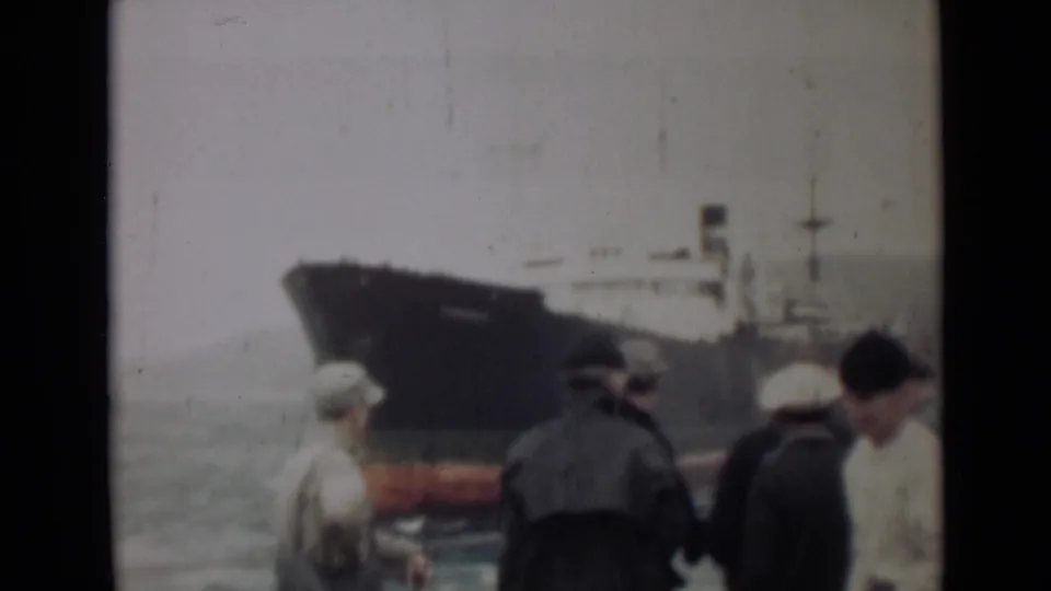 In the final 1946 India frame, men stand at the waterfront while a dark ship with a red lower hull dominates the hazy background.