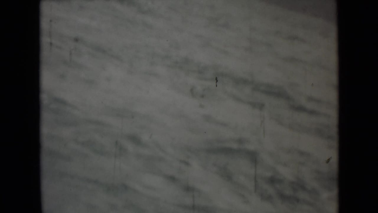 Soft 8mm frame of rough gray water, with film borders and scratches visible during the maritime scene.