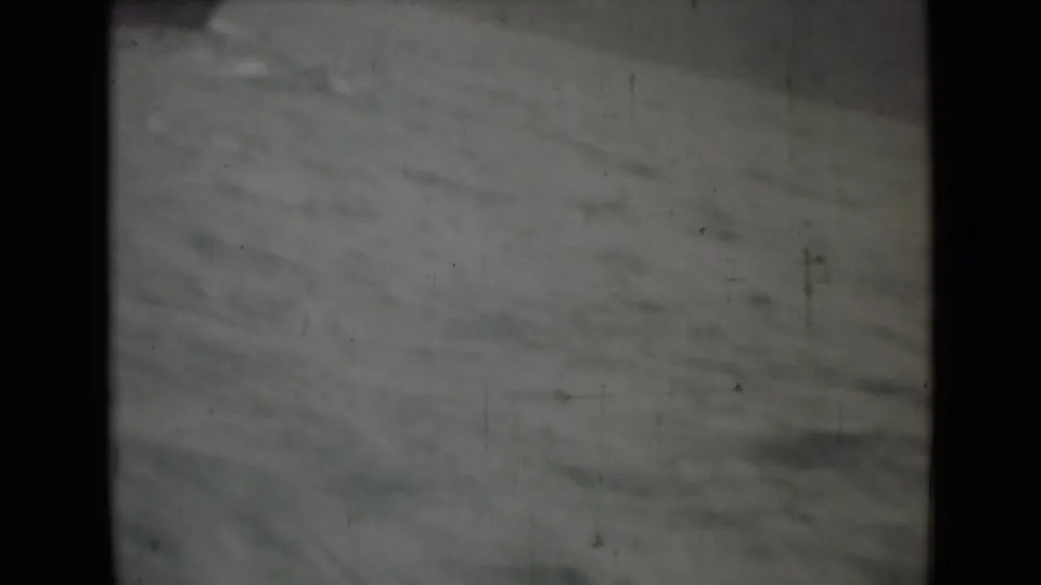 1946 India 8mm frame showing rough water and a small distant dark shape near the bottom of the shot.