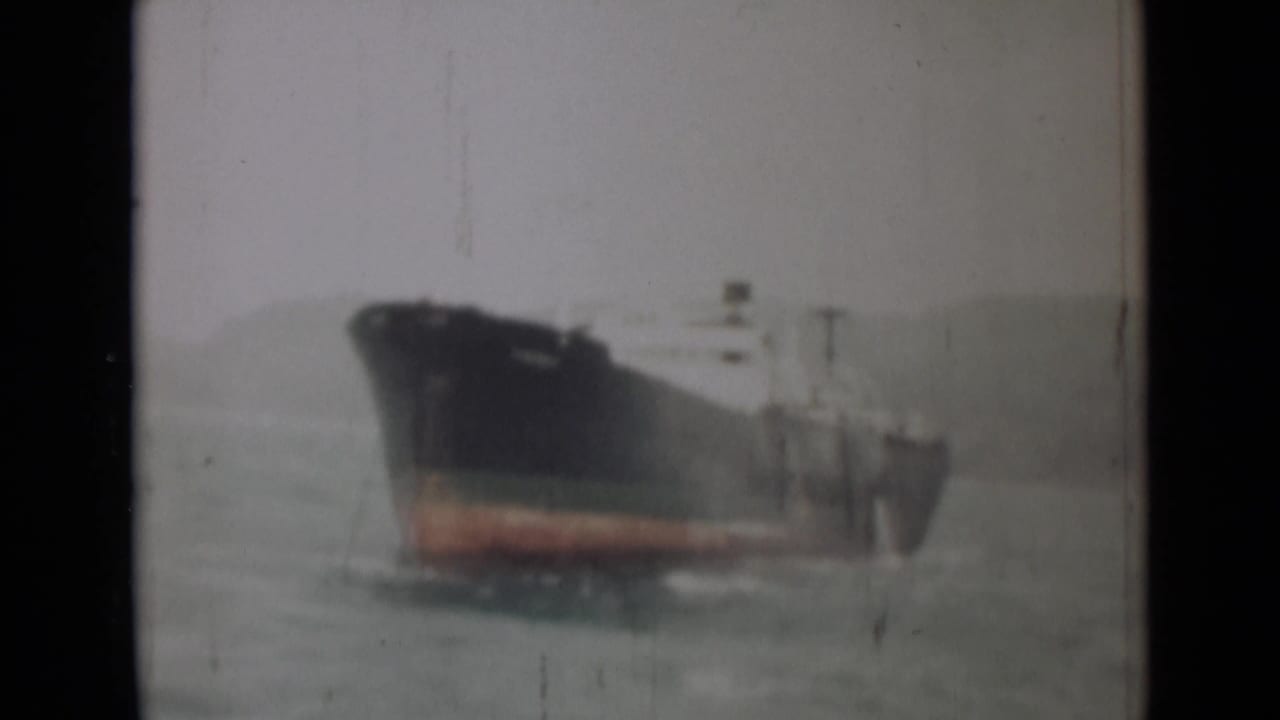 1946 India 8mm frame of the cargo ship moving through gray-green water with soft focus and visible film wear.