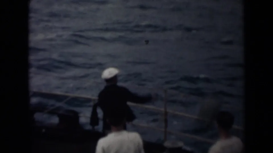 1946 India 8mm deck view with a crew member in a white cap by the railing and dark water beyond.