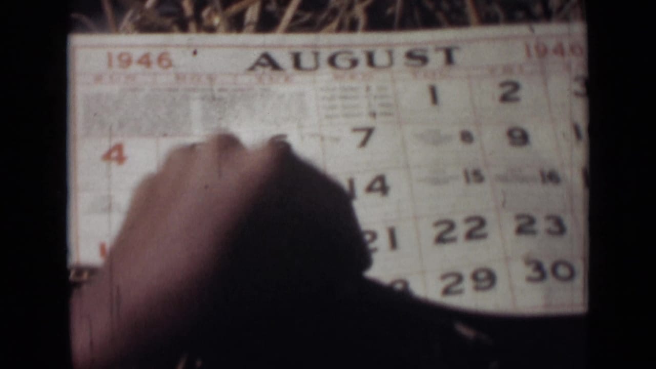 Hand holds down an August 1946 calendar page near the numbered dates.