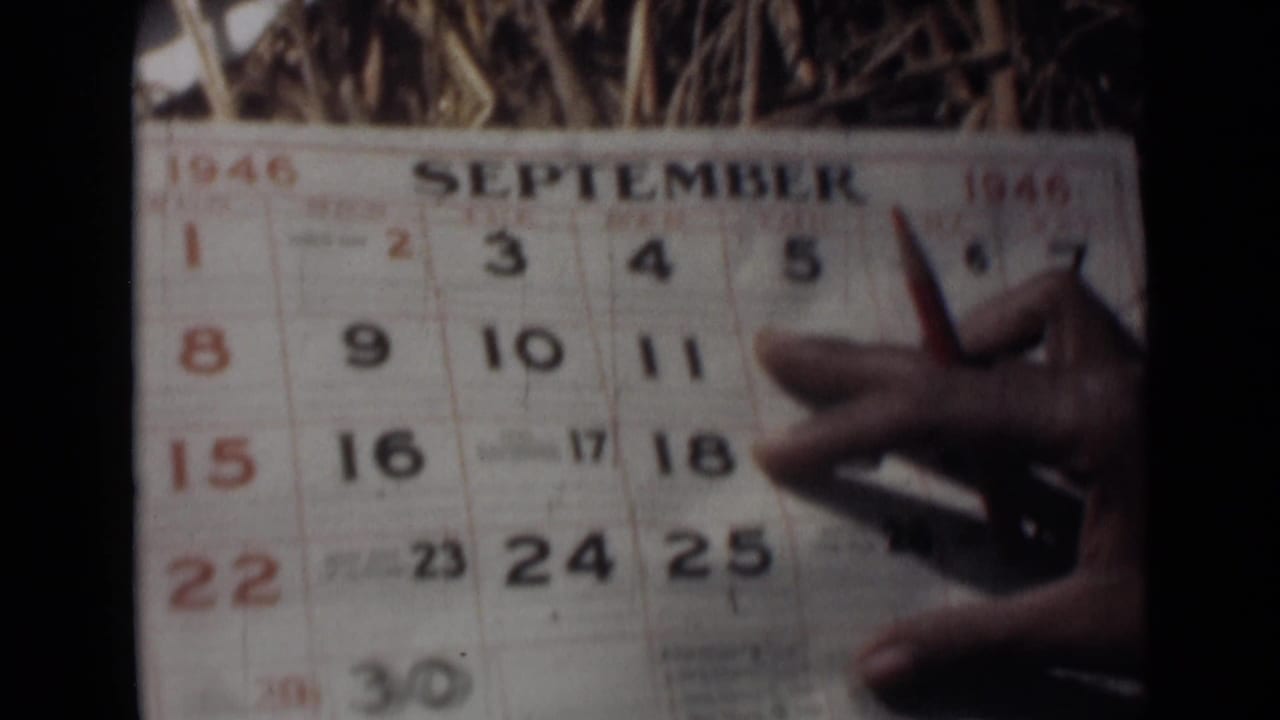 September 1946 calendar page appears with a hand and pointed object near the printed date grid in grainy 8mm footage.