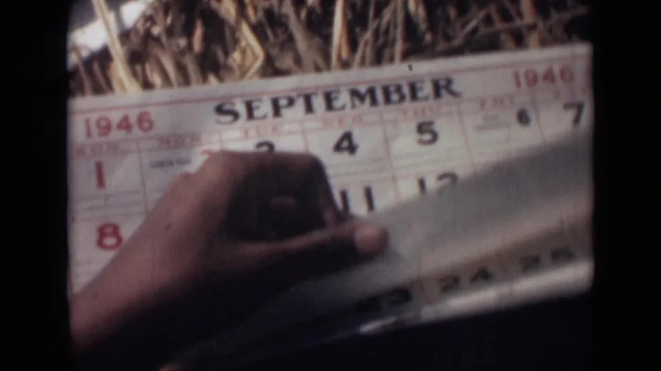 A hand turns or holds the lower edge of a September 1946 calendar page, with the date grid visible in soft 8mm color.