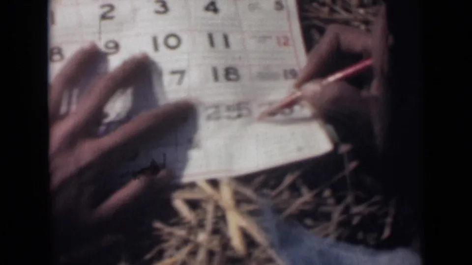 A red pencil marks the lower portion of the October 1946 calendar while another hand holds the paper steady on straw.