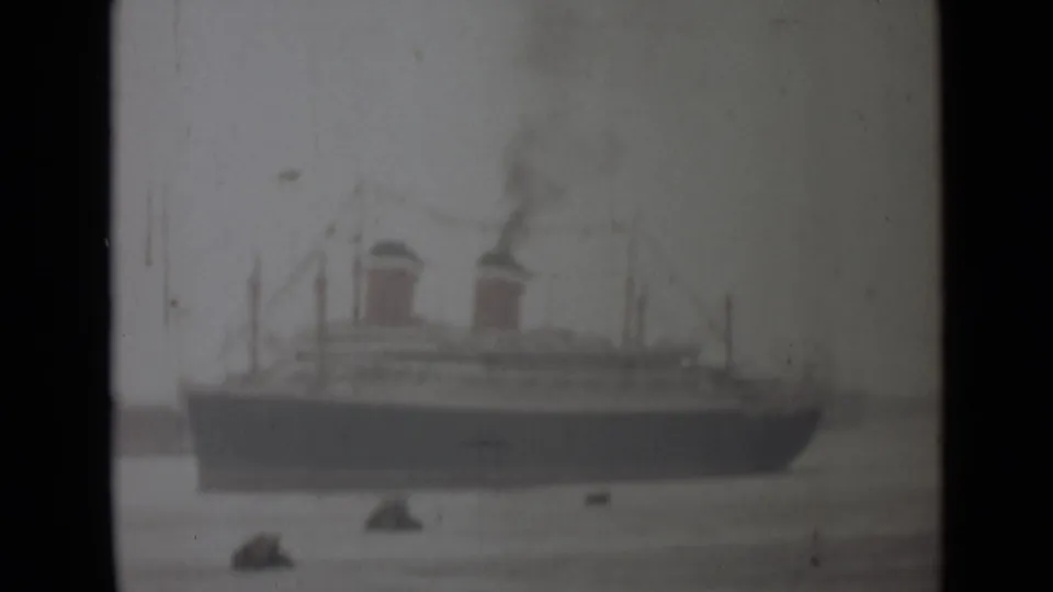 Faded 1946 India 8mm frame showing a large passenger ship in profile, with two smoking funnels and small boats on calm water.