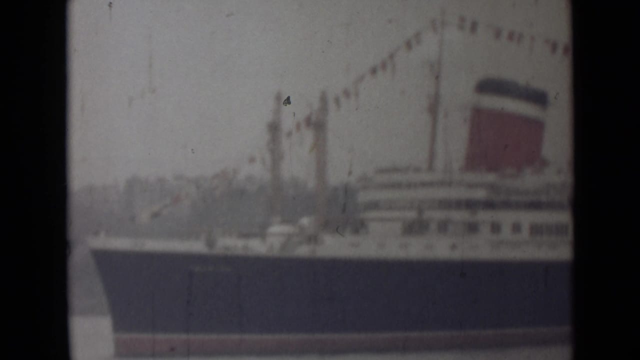1946 India 8mm frame showing a closer section of the liner with signal flags strung above the decks and a red funnel.