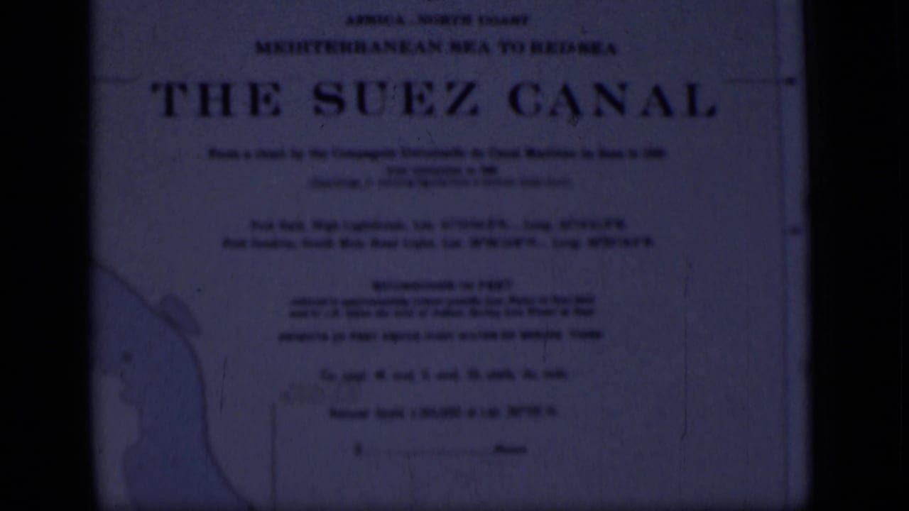Soft blue-tinted frame of a Suez Canal sign with large title text and partial map outline.