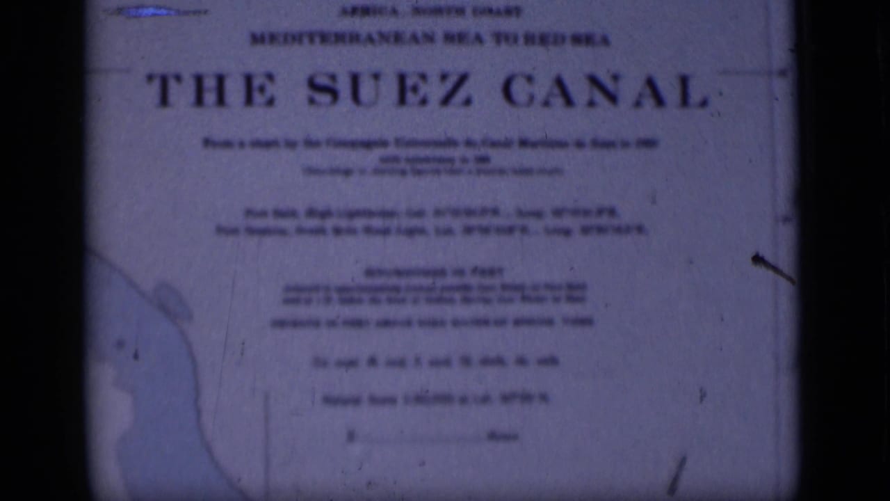 1946 8mm frame showing the Suez Canal sign, with Mediterranean-to-Red-Sea wording, soft focus and visible film wear.