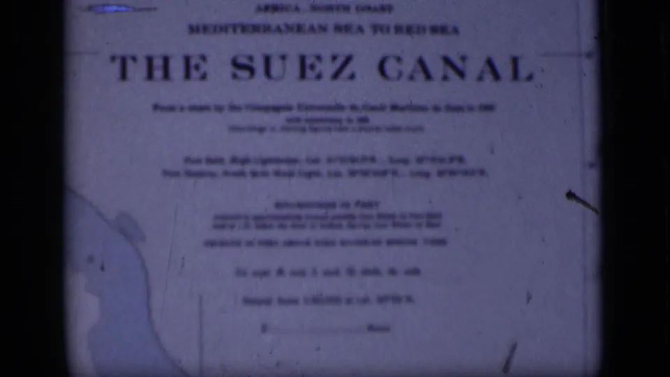 1946 8mm frame showing the Suez Canal sign, with Mediterranean-to-Red-Sea wording, soft focus and visible film wear.