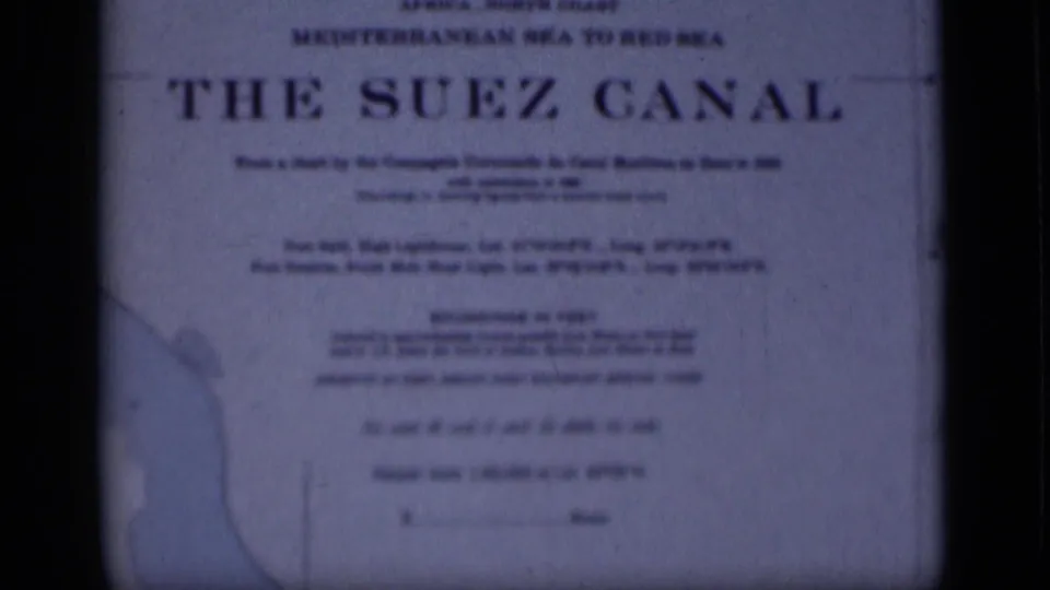 1946 Egypt 8mm frame of The Suez Canal sign, showing soft typography, a left-side map outline and blue-toned film texture.