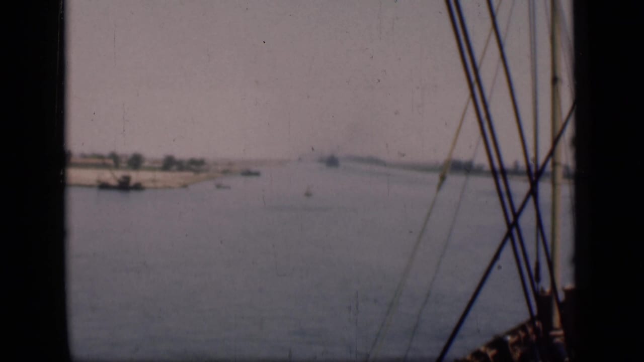 1946 Suez Canal footage showing a wide water view from a boat, with rigging at right and low banks beyond.