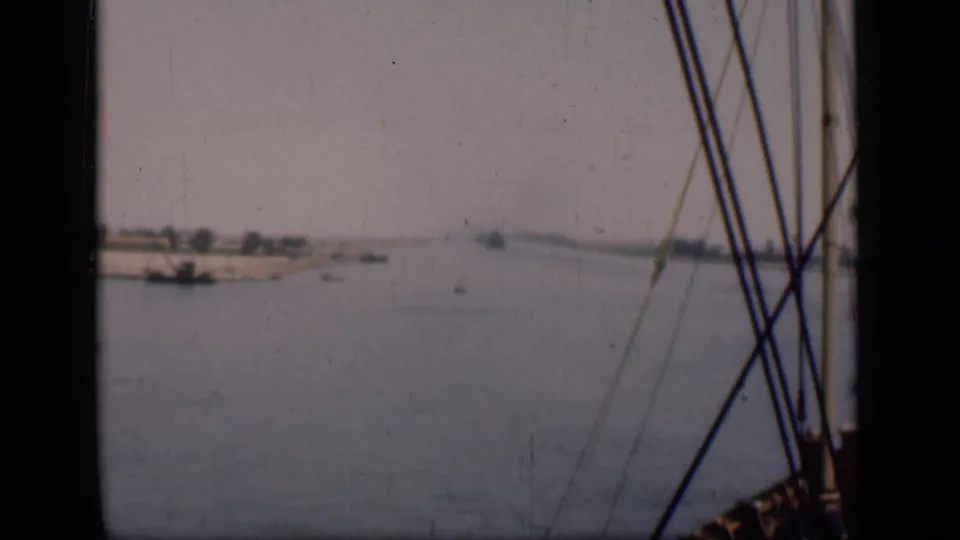 1946 Suez Canal footage showing a wide water view from a boat, with rigging at right and low banks beyond.
