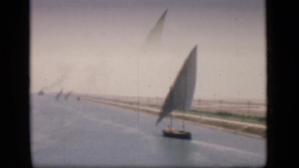 Soft 1946 Suez Canal frame showing a felucca from farther away, with faint sailboats along the canal line.