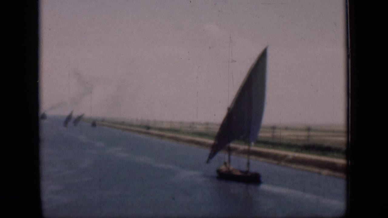 A felucca with a tall triangular sail moves along the Suez Canal in 1946-era 8mm home-movie footage.