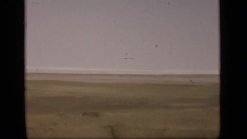 The final frame shifts away from the boats to a flat Suez Canal-side landscape with muted water, bank, and sky tones.