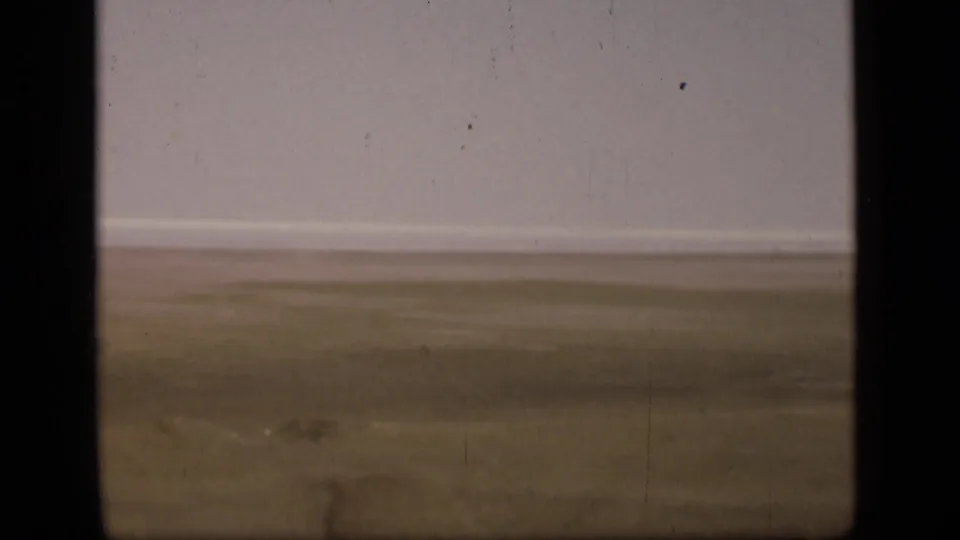 The final frame shows flat open ground near the Suez Canal, a pale sky, and aged 8mm film texture.