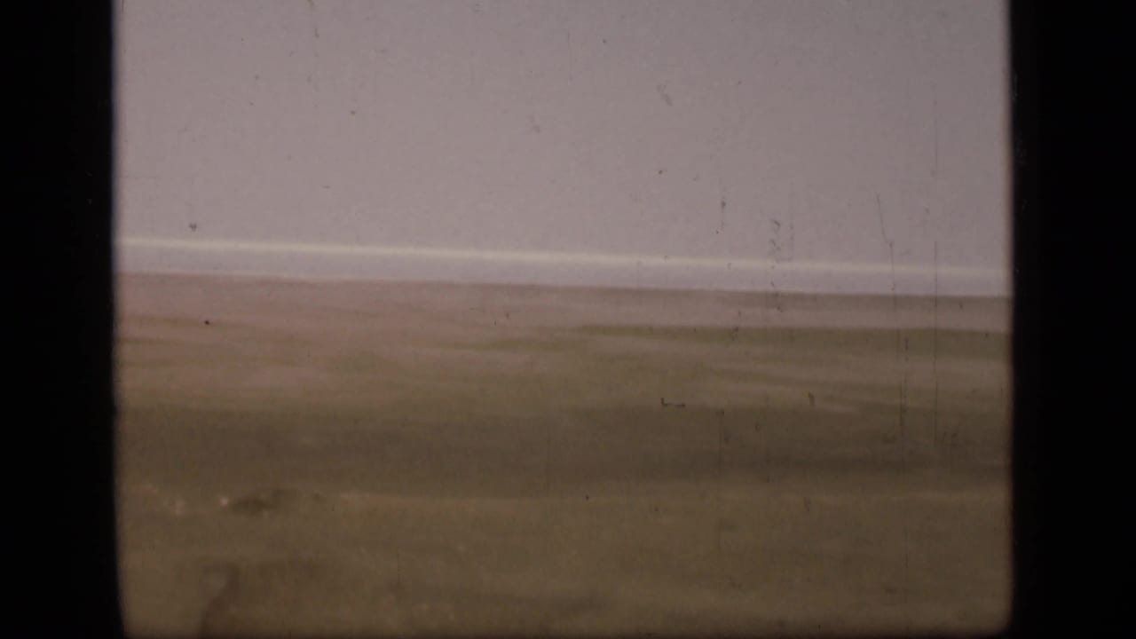 1946 home-movie frame showing a sparse desert view near the Suez Canal region, with soft focus and visible physical-film marks.