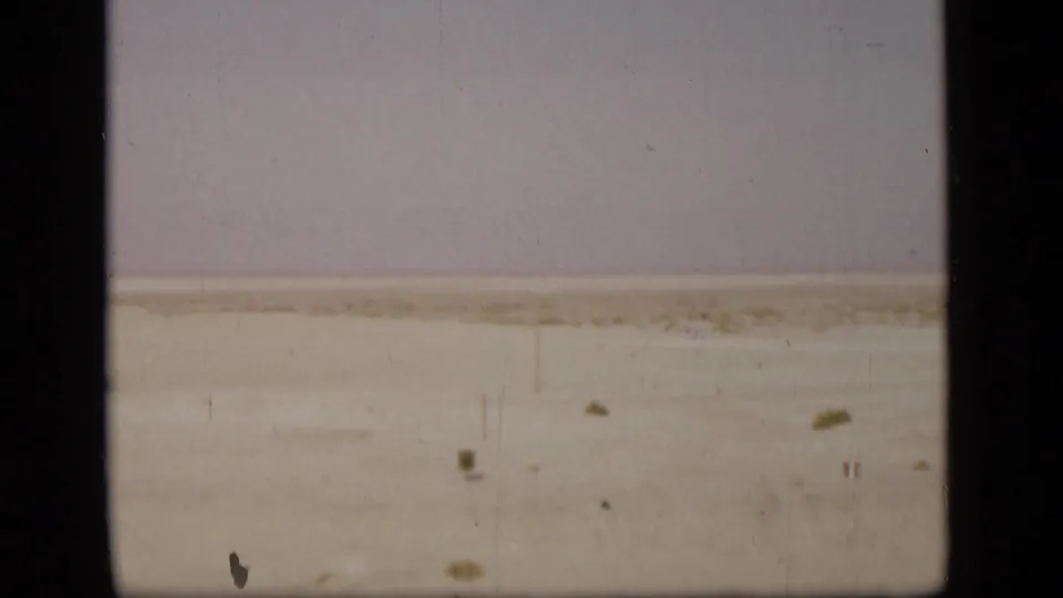Suez Canal shoreline and waterway appear in faded 8mm color, with a dark border cutting through the frame.