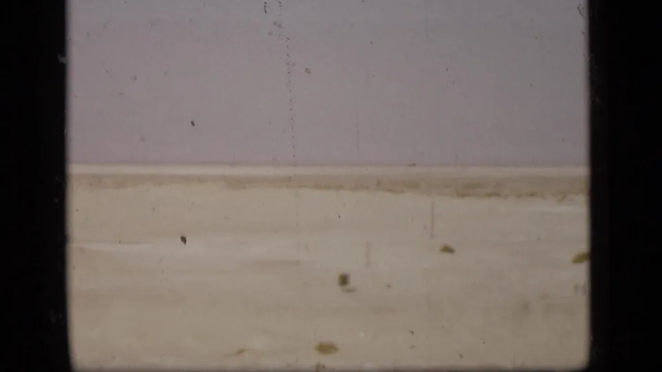 A pale Suez Canal-side landscape appears in soft, faded 8mm color with dust and vertical film marks.
