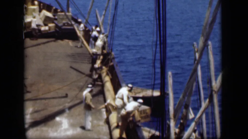 On the Suez Canal in 1946, men in white robes and Arab headdresses stand near a cargo vessel's gunwale and rigging.