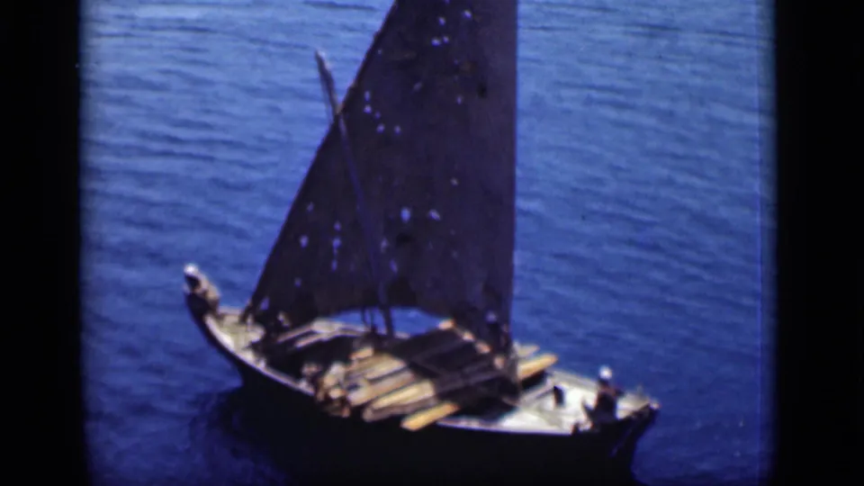 The 1946 Suez Canal footage shows a closer view of a wooden sailboat with passengers and stacked boards under a dark sail.