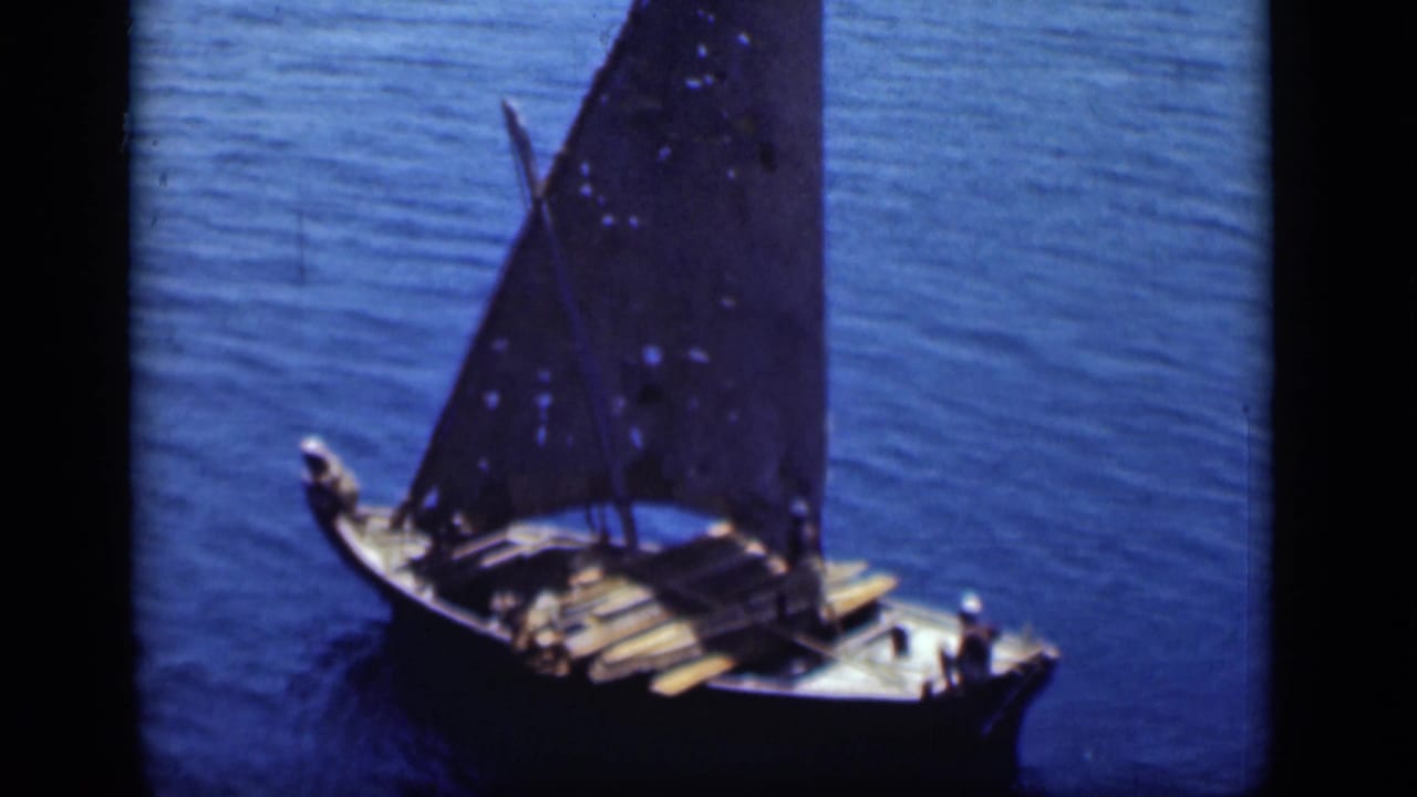 A traditional wooden sailboat with crew visible on deck crosses blue water in Suez Canal footage from 1946.