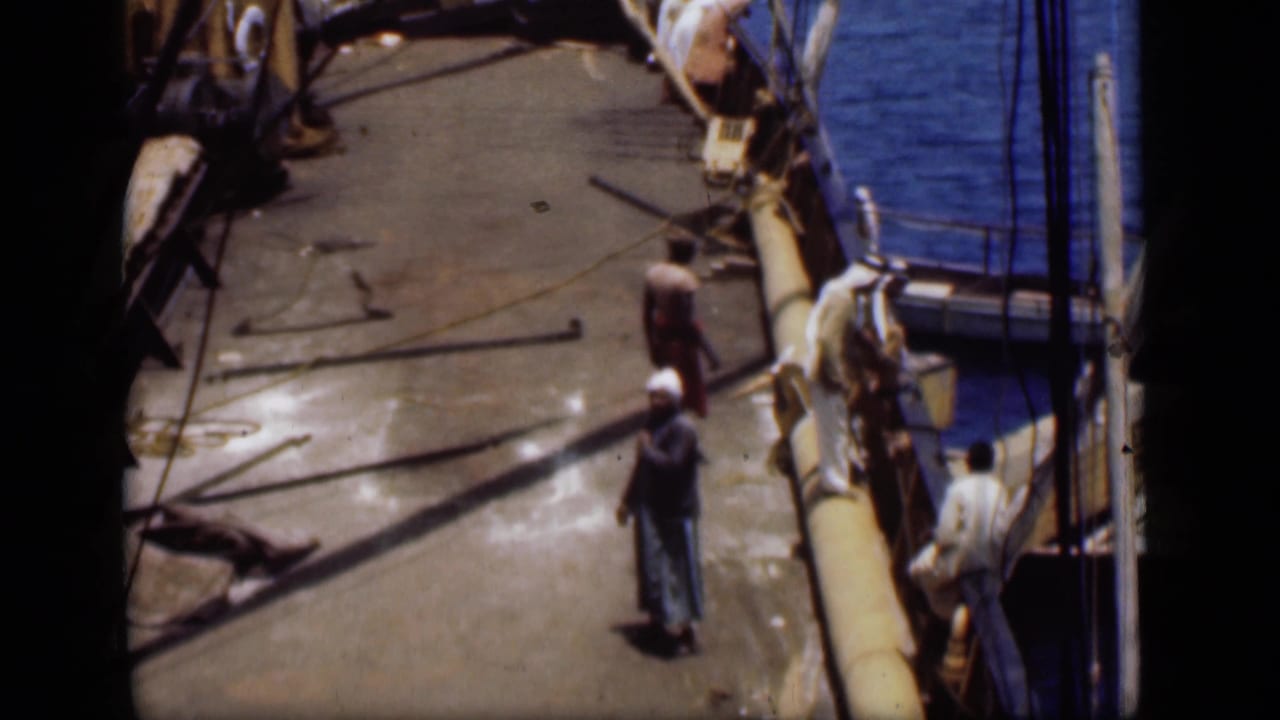 1946 Suez Canal deck scene showing men near ropes, railings and blue water beside the boat.