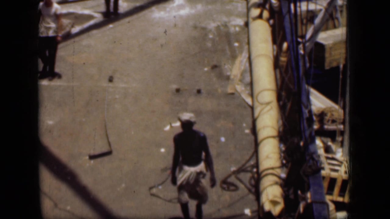 In 1946 Suez Canal footage, a man in a white headwrap and light cloth walks across a sunlit boat deck.