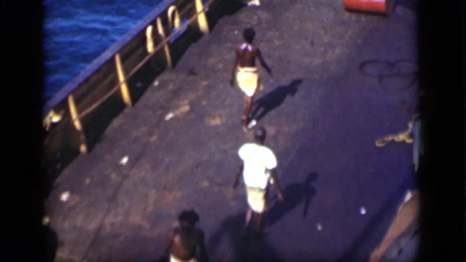 1946 Suez Canal ship deck view with two men walking near yellow railings, ropes, and blue water.