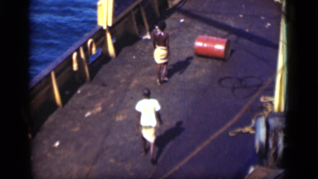 1946 Suez Canal deck scene with two men approaching a red barrel near the ship rail and blue water.