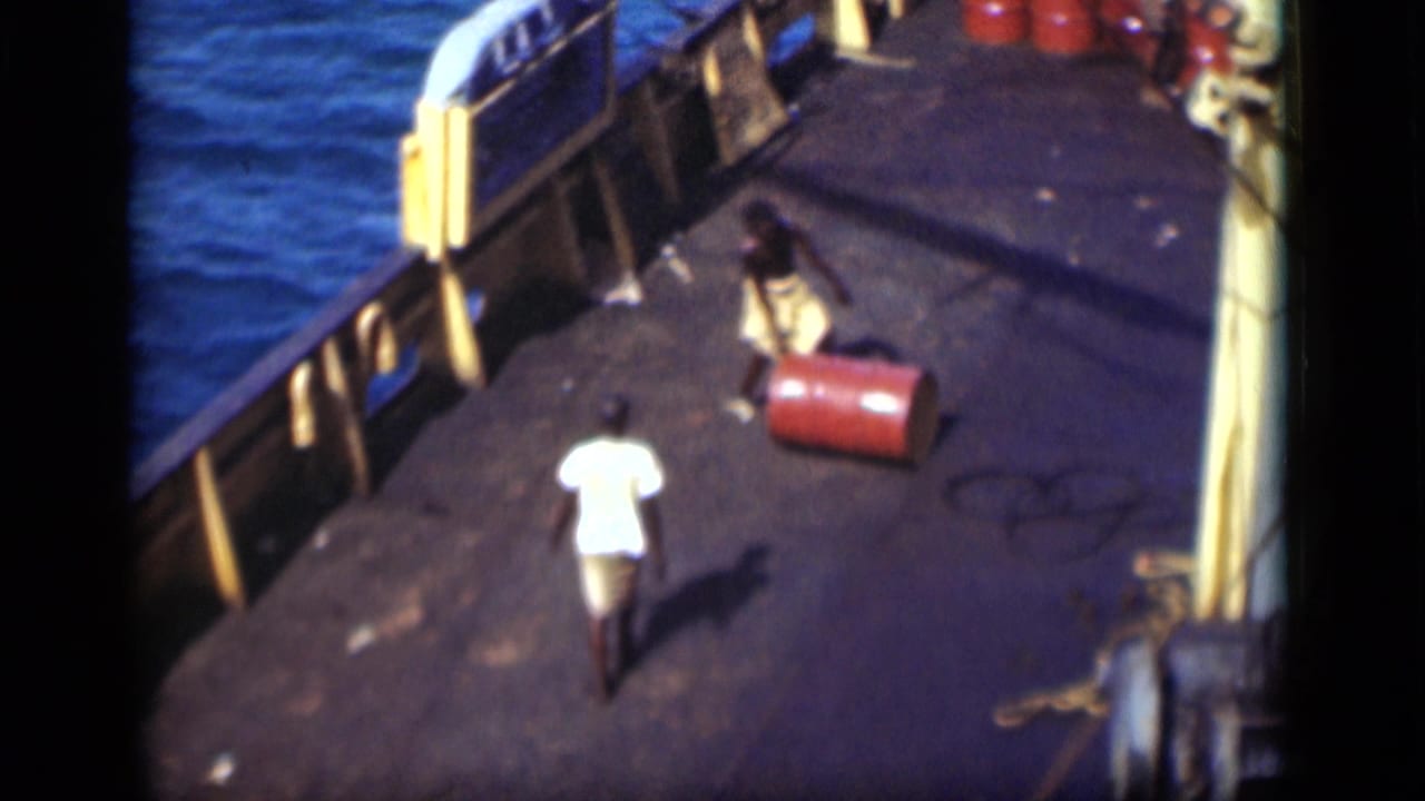 On a 1946 Suez Canal ship deck, one man appears to handle a red barrel while another walks nearby.