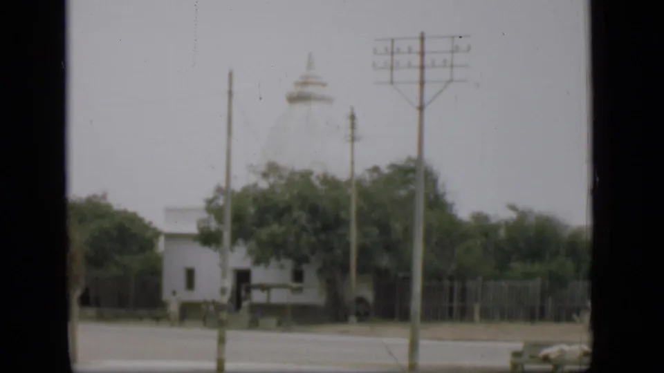 A 1946 home-movie frame shows the same white domed religious building across a Suez Canal area street.