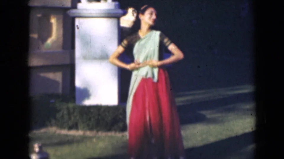 In the final frame, the woman stands smiling with hands clasped near a white pillar, with the brass pot visible low at the edge of the grass.