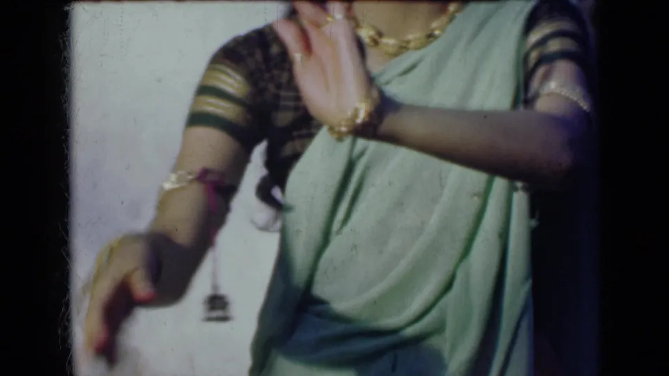 In the final frame, one adorned hand rises and the other lowers beside the woman’s green sari.