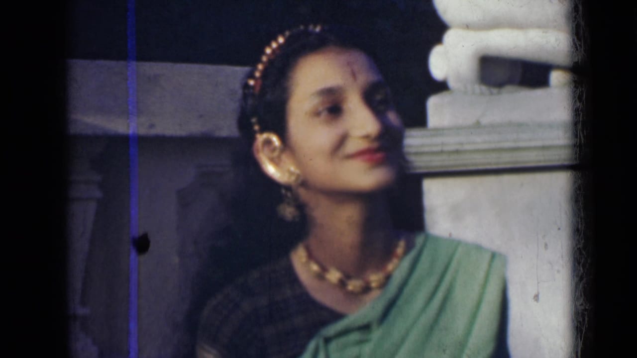 Woman in sari turns her head beside a column.