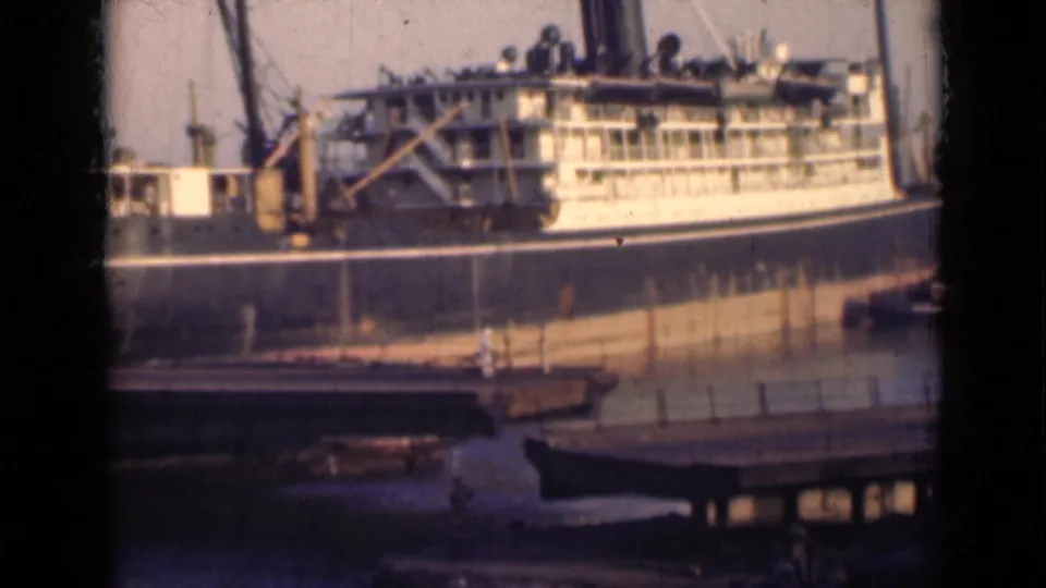 A similar harbor view shows the steamship alongside the dock, with rigging, hull, and foreground water in soft archival color.